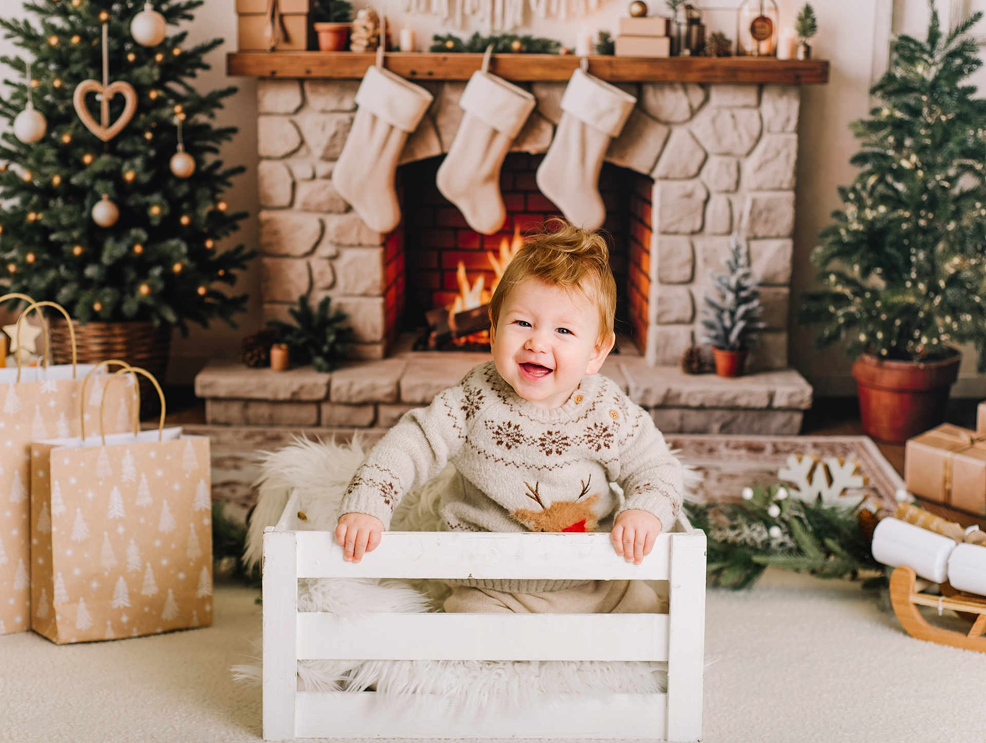 Bjorn is registered to the contest to win money with this photo: baby, carpet, child, christmas_tree, cozy, crate, decorations, festive, fireplace, fur, gifts, happy, holiday, indoor, potted_plants, reindeer, smile, stockings, sweater, wood