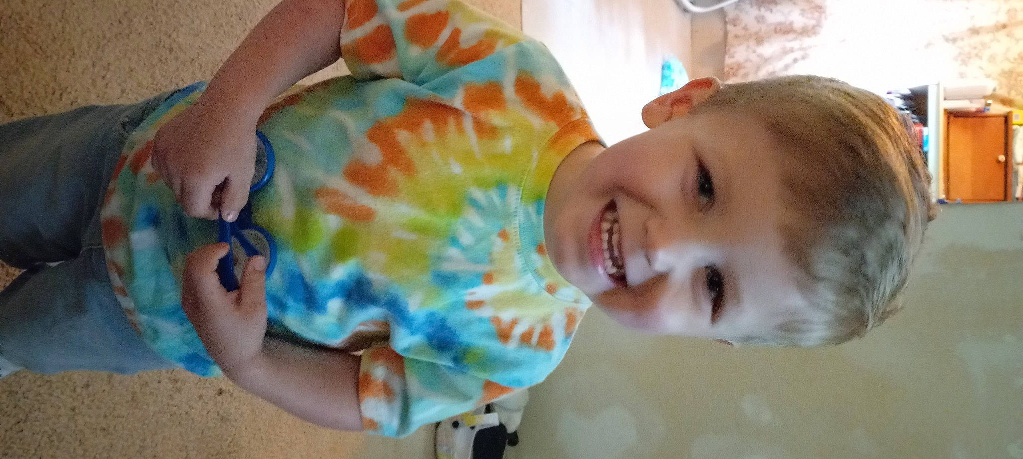 Devin is registered to the contest to win money with this photo: child, dress, fashion_accessory, finger, fun, gesture, hand, happy, joy, leisure, musical_instrument, nail, pattern, peach, people, person, plant, play, smile, thumb