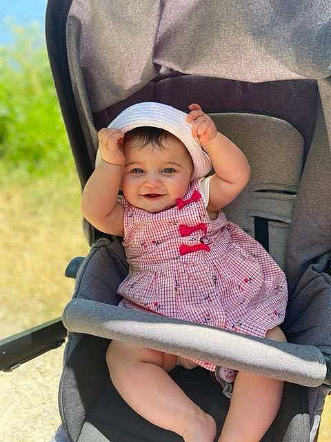 Carla participe au concours pour gagner de l'argent avec cette photo : baby, baby_carriage, baby_products, car_seat, chair, child, headwear, joy, leg, person, pink, product, sitting, skin, smile, toddler, vacation