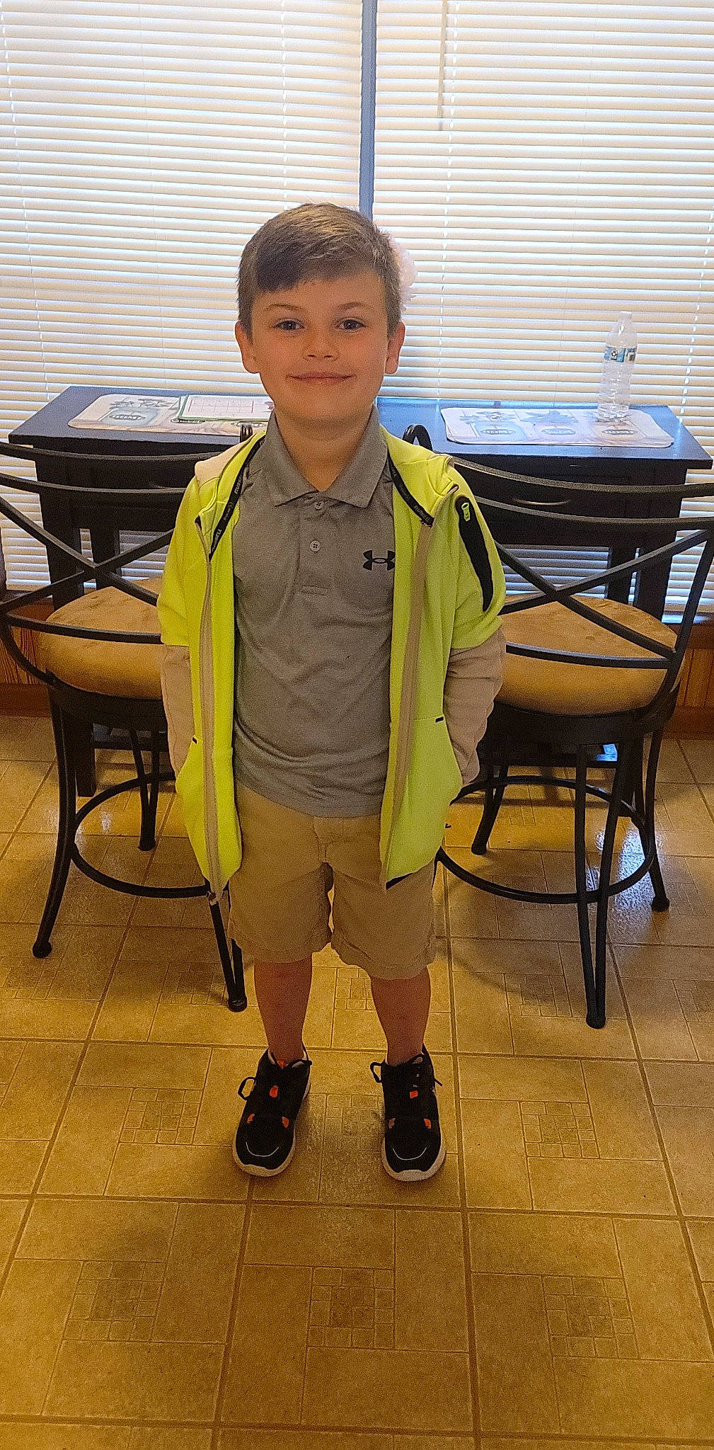 Mathew joined the competition — help win amazing prizes! chair, child, dress_shirt, flooring, furniture, happy, hardwood, joy, leisure, person, room, shorts, sitting, sleeve, smile, standing, table, toddler, uniform, wood