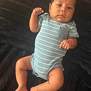 Thiago Marquez joined the competition — help win amazing prizes! baby, infant, child, portrait, lying_down, striped_onesie, blue_clothing, blanket, fluffy_blanket, indoor, close_up, face, eyes_open, fist, arms, legs, bare_feet, serious_expression, soft_lighting, candid_photo