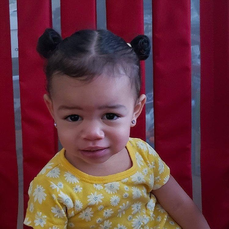 Nyla is registered to the contest to win money with this photo: baby_toddler_clothing, bun, cheek, child, chin, eyelash, fun, hair, happy, iris, magenta, neck, person, sitting, skin, sleeve, smile, toddler