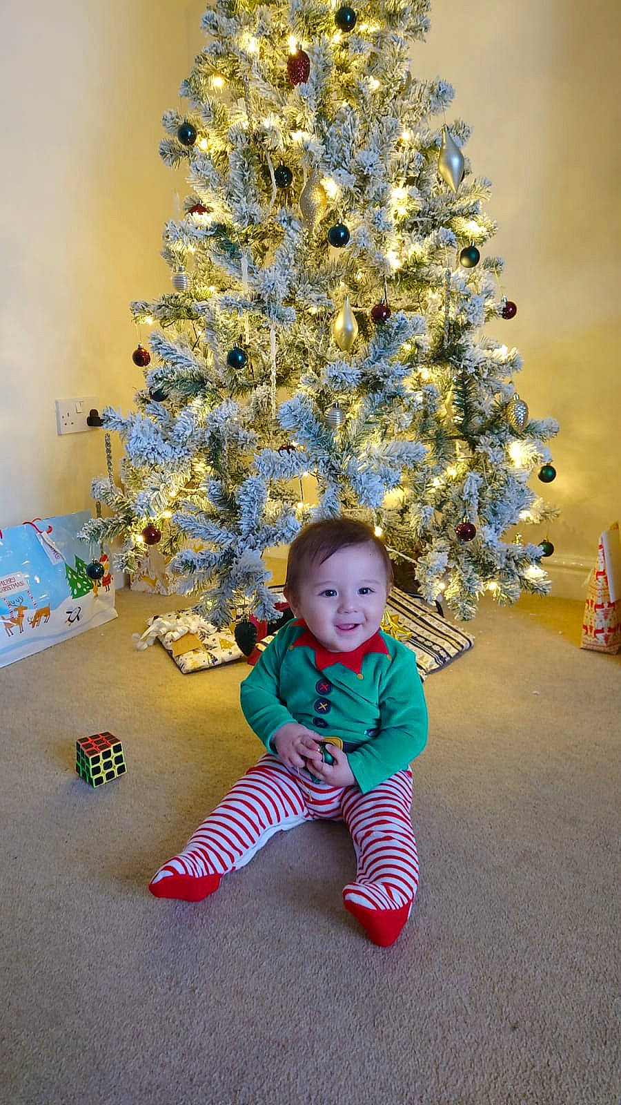 Billy is registered to the contest to win money with this photo: baby_toddler_clothing, child, christmas, christmas_decoration, christmas_ornament, christmas_tree, conifer, electric_blue, event, evergreen, fun, happy, holiday, holiday_ornament, joy, ornament, person, plant, smile, standing