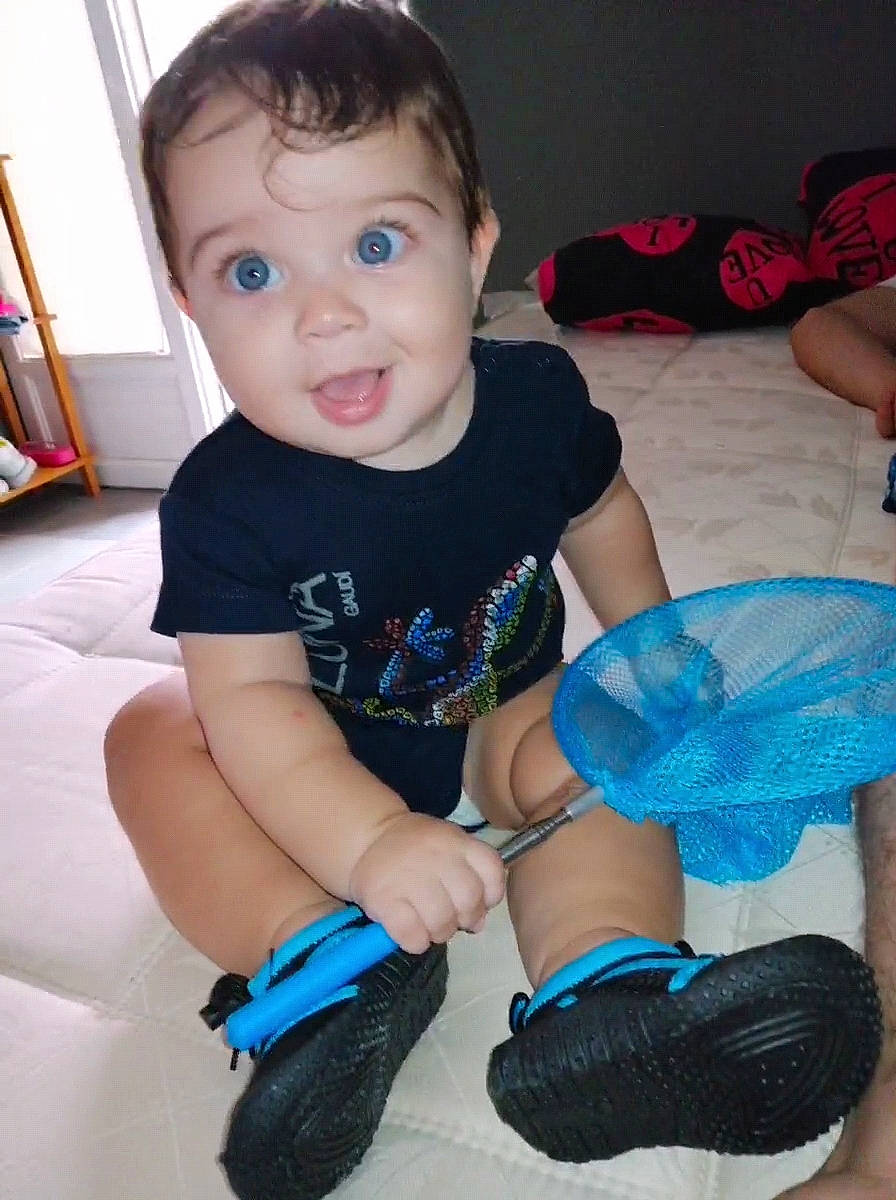 Santiago a rejoint le concours — aidez-le/la à gagner de superbes lots ! baby, baby_toddler_clothing, black, bookcase, child, electric_blue, eye, finger, fun, human_leg, knee, person, sitting, sleeve, smile, sock, t_shirt, thigh, toddler, white