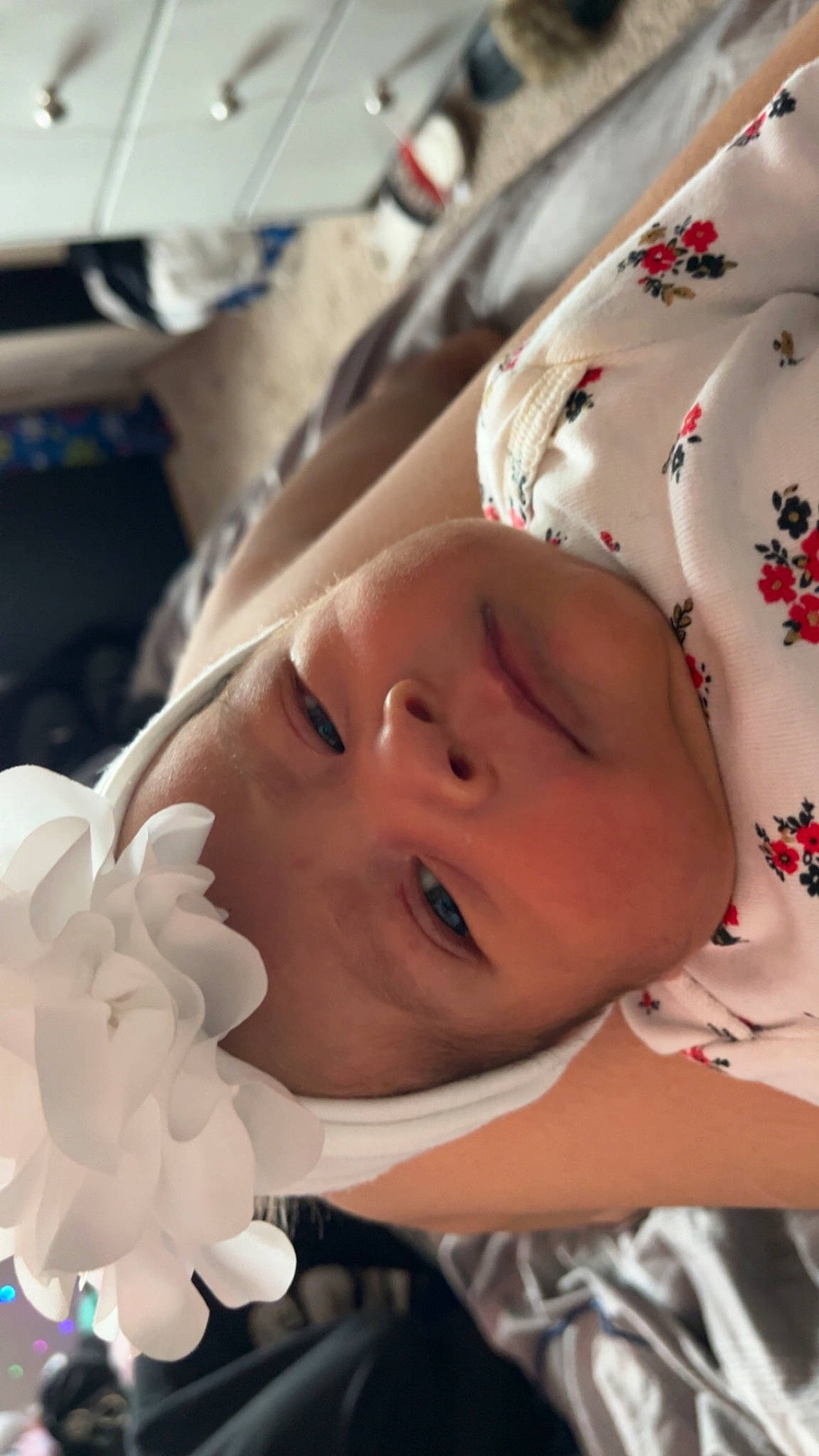 Esme is registered to the contest to win money with this photo: baby, baby_products, cheek, child, chin, close_up, eye, eyebrow, eyelash, face, hand, happy, head, headgear, headwear, lip, mouth, nose, person, petal