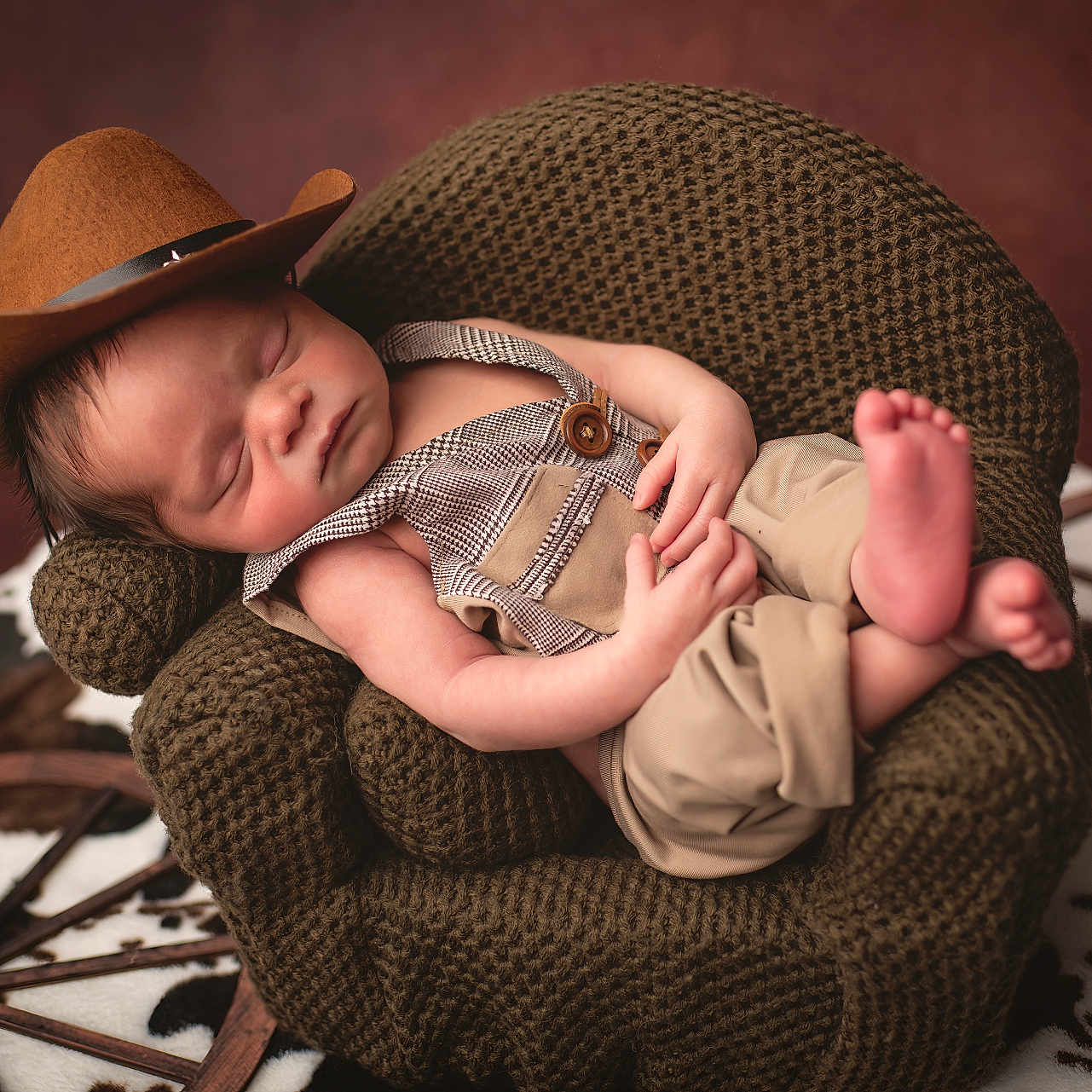 Houston joined the competition — help win amazing prizes! baby, brown, cowboy_hat, cowhide_rug, cozy, crocheted_chair, face, hands, hat, knit_chair, little_feet, newborn, overalls, peaceful, portrait, props, skin, sleeping, studio, wooden_wheel