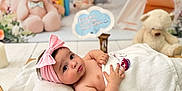 Diana joined the competition — help win amazing prizes! baby, blanket, child, curious, cute, decor, headband, indoor, infant, laying_down, nursery, pink_bow, plush_toy, portrait, rainbow, soft_lighting, teddy_bear, towel, toy, wooden_floor