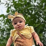 Diana joined the competition — help win amazing prizes! baby, child, yellow_clothing, headband, hand, outdoor, greenery, tree, nature, portrait, infant, cute, person, arm, skin, face, expression, holding, summer, daylight