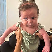 Novalee joined the competition — help win amazing prizes! baby, infant, child, hair, spiky_hair, green_outfit, hands, indoor, expression, person, skin, arm, face, cute, young, newborn, holding, casual, room, portrait