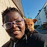Véo participe au concours pour gagner de l'argent avec cette photo : building, casual, daylight, dog, face, glasses, happy, jacket, nature, outdoor, person, pet, portrait, puppy, shoulder, sky, smile, street, urban, young_adult