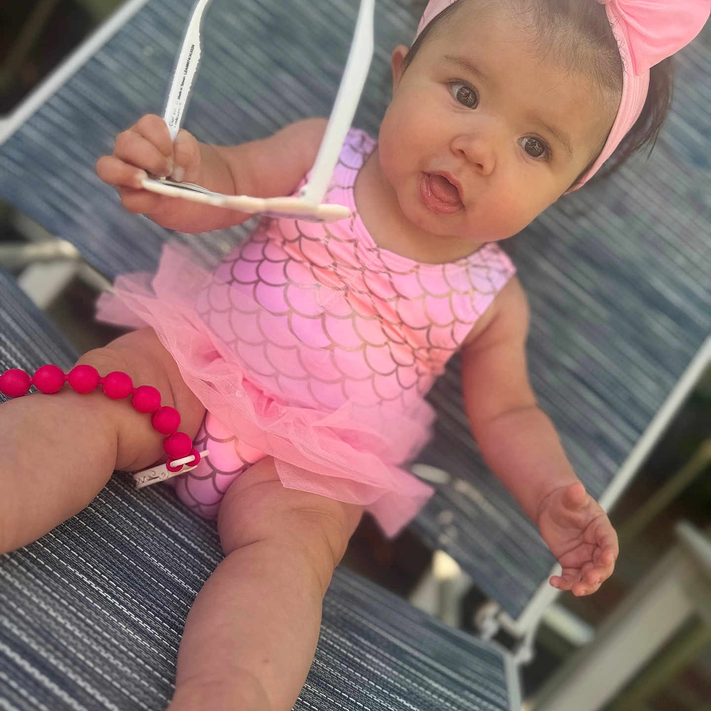 Princess Octavia joined the competition — help win amazing prizes! arm, baby, child, curious, cute, expression, face, headband, infant, legs, lounge_chair, mermaid_pattern, outdoor, person, pink_bow, sitting, summer, sunglasses, swimsuit, tutu