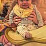 baby, child, person, smile, bow, bib, clothing, hand, carousel, horse, flower, colorful, toy, amusement_park, happy, fun, indoor, jacket, adidas, portrait