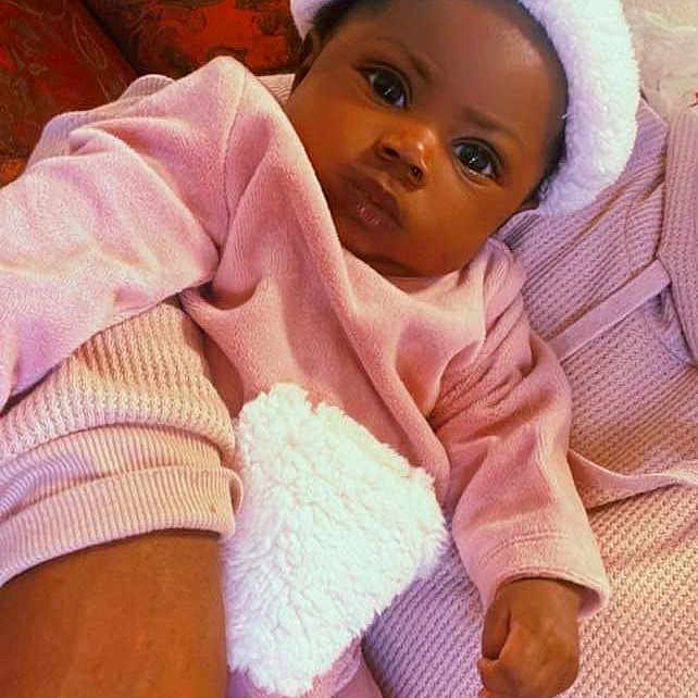 Leveigh is registered to the contest to win money with this photo: baby, blanket, bonnet, cap, clothing, couch, cushion, face, furniture, glove, happy, hat, head, homedecor, person, photography, portrait, purple, sitting, toy