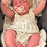 newborn, baby, infant, sleeping, pacifier, bow, headband, dress, floral, car_seat, blanket, portrait, face, arms_raised, bare_feet, cozy, indoors, child, resting, cute