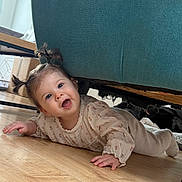 Lucy participe au concours pour gagner de l'argent avec cette photo : baby, child, pigtails, smiling, floor, wooden_floor, couch, teal_couch, indoor, cat, black_cat, happy, cute, cozy, clothing, person, home, furniture, portrait, playful