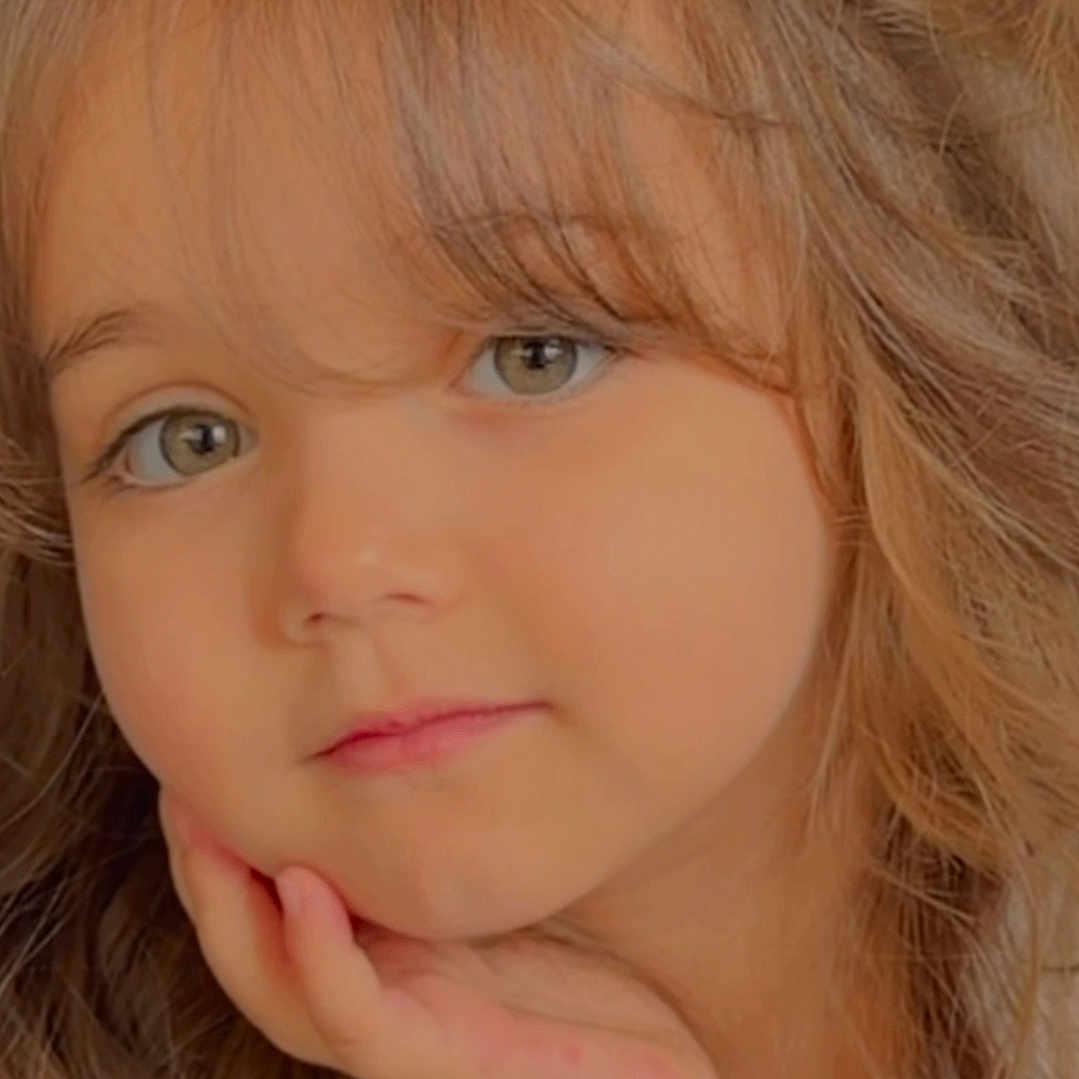 Layane a rejoint le concours — aidez-le/la à gagner de superbes lots ! child, portrait, close_up, face, expression, thoughtful, wavy_hair, blond_hair, hand_on_chin, casual_clothing, soft_lighting, indoor, cute, young_child, person, looking_at_camera, skin, eyebrows, long_hair, innocent
