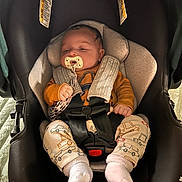 Zaiden joined the competition — help win amazing prizes! baby, car_seat, pacifier, infant, safety_harness, clothing, socks, patterned_pants, cute, sleepy, indoor, child, person, seat, fabric, soft_lighting, comfort, resting, small_hands, head