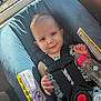 Zoey is registered to the contest to win money with this photo: baby, car_seat, bottle, child, smile, seatbelt, window, sunlight, indoor, clothing, face, infant, safety, cute, person, seat, happy, resting, holding, young