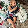 Zoey is registered to the contest to win money with this photo: baby, sleeping, sneaker, blanket, carpet, plastic_bag, diaper, clothing, infant, floor, toddler, indoor, cute, peaceful, hand, foot, face, person, child, resting