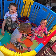 Zoey joined the competition — help win amazing prizes! child, baby, playpen, toy, outdoor, smile, colorful, foam_mat, plastic_panel, car_toy, happy, playtime, sitting, clothing, shoe, stroller, brick_wall, grill, sunlight, person