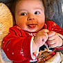 baby, infant, child, smiling, tongue_out, red_sweater, holiday_sweater, cozy_blanket, plush_pillow, chubby_cheeks, brown_hair, big_eyes, hands, portrait, indoor, cute, playful, blanket, fuzzy, festive