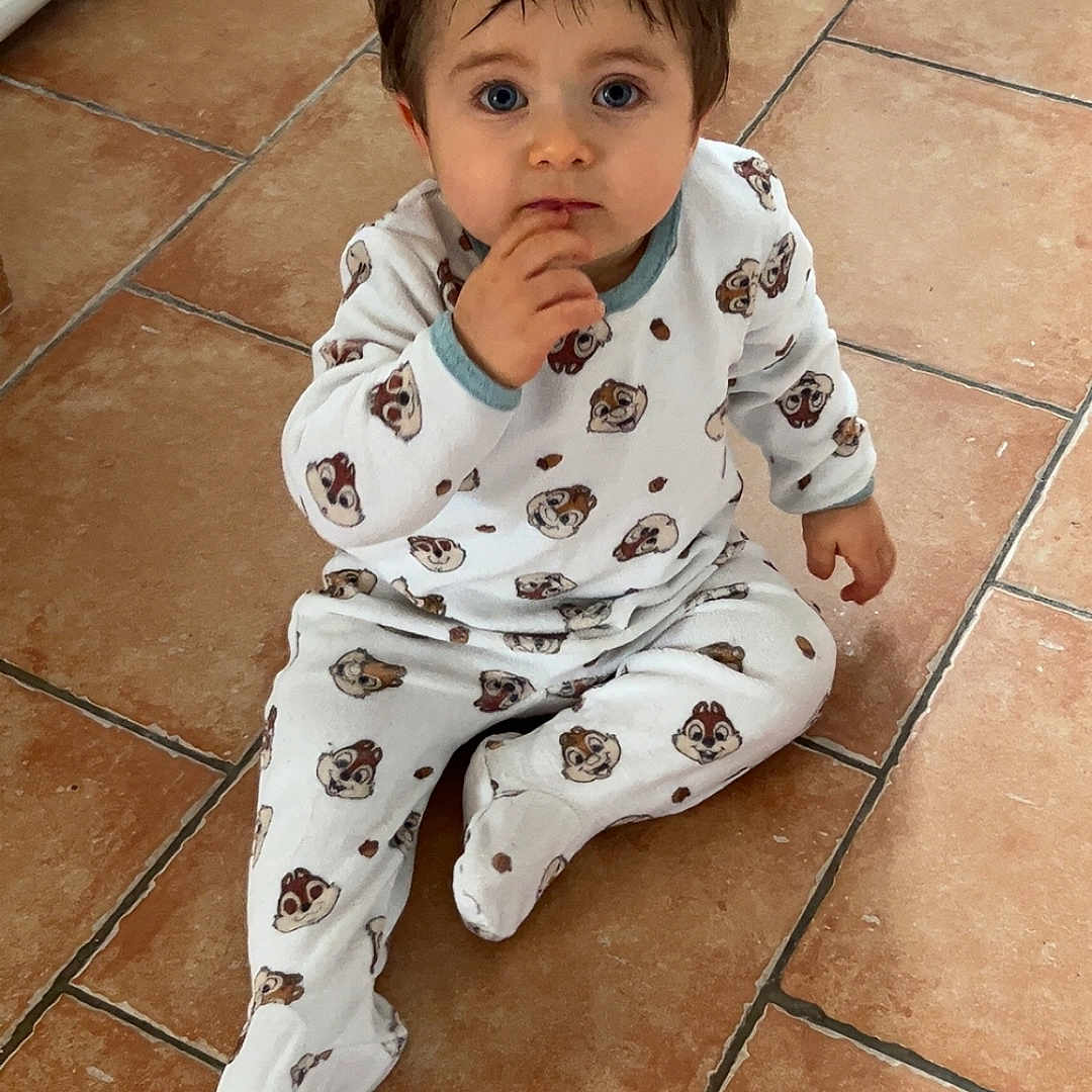 ézechiel a rejoint le concours — aidez-le/la à gagner de superbes lots ! baby, blue_eyes, ceramic_tiles, child, curly_hair, cute, expression, face, feet, flooring, hand_to_mouth, home, indoor, looking_up, one_person, pajamas, portrait, sitting, tile_floor, toddler