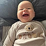 baby, smiling, infant, onesie, striped_clothing, koala_patch, happy, cute, lying_down, indoors, child, portrait, soft_surface, closeup, cheerful, young_child, casual_clothing, fabric, adorable, face