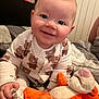 Logan joined the competition — help win amazing prizes! baby, child, smiling, pajamas, bed, plush_toy, tiger, orange, white, bedroom, cozy, cute, person, infant, soft_toy, sitting, happy, face, hand, cuddly
