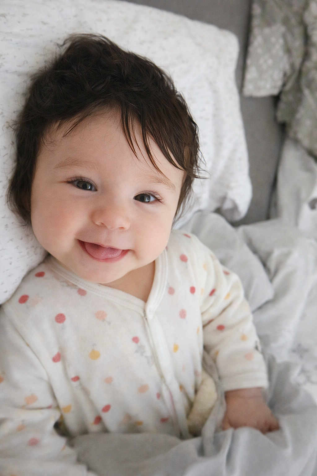 Catalia participe au concours pour gagner de l'argent avec cette photo : baby, child, smiling, face, bed, blanket, onesie, polka_dots, hair, happy, infant, cute, portrait, lying_down, indoors, soft_lighting, bedding, comfort, toddler, expression