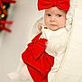 baby, infant, red_bow, red_dress, white_clothing, wooden_cradle, face, blue_eyes, fur_trim, holiday, christmas, decorations, soft_lighting, portrait, indoor, cute, child, cozy, festive, newborn