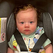 Lucas joined the competition — help win amazing prizes! baby, infant, child, car_seat, harness, safety, portrait, face, eyes, looking_at_camera, serious_expression, seated, indoors, vehicle, colorful_clothing, short_sleeves, padded_seat, photography, close_up, safe
