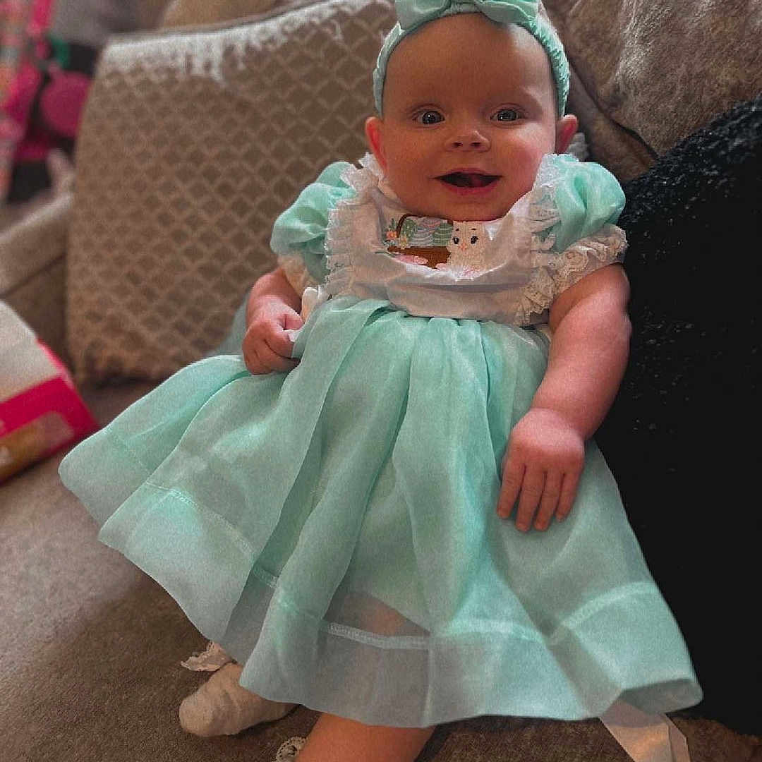 Bambi-Mai joined the competition — help win amazing prizes! baby, bonnet, clothing, costume, couch, cushion, dress, face, footwear, formalwear, furniture, happy, hat, head, homedecor, newborn, person, photography, portrait, sitting