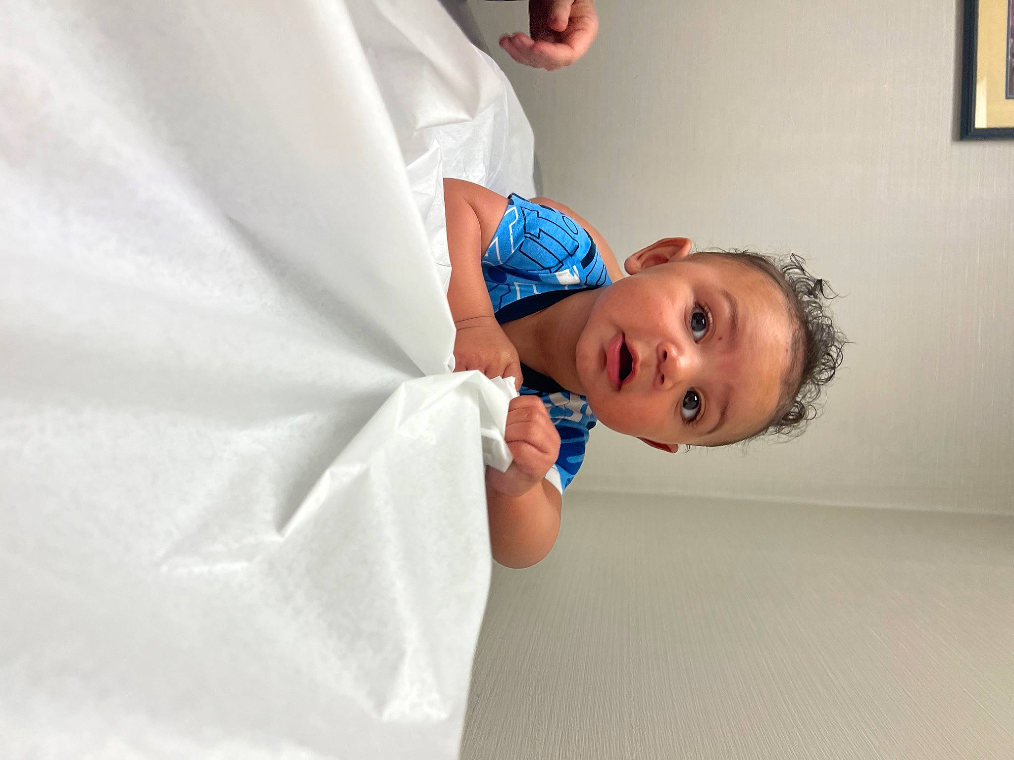 Randall is registered to the contest to win money with this photo: baby, baby_toddler_clothing, cap, child, elbow, electric_blue, fashion_accessory, flooring, fun, gesture, happy, person, picture_frame, portrait_photography, room, sleeve, smile, surprise, t_shirt, toddler