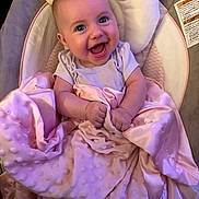 Kinsley is registered to the contest to win money with this photo: baby, smiling, blanket, pink, infant, happy, face, child, cushion, soft, clothing, seat, indoors, cute, portrait, newborn, person, sitting, wrapped, comfort