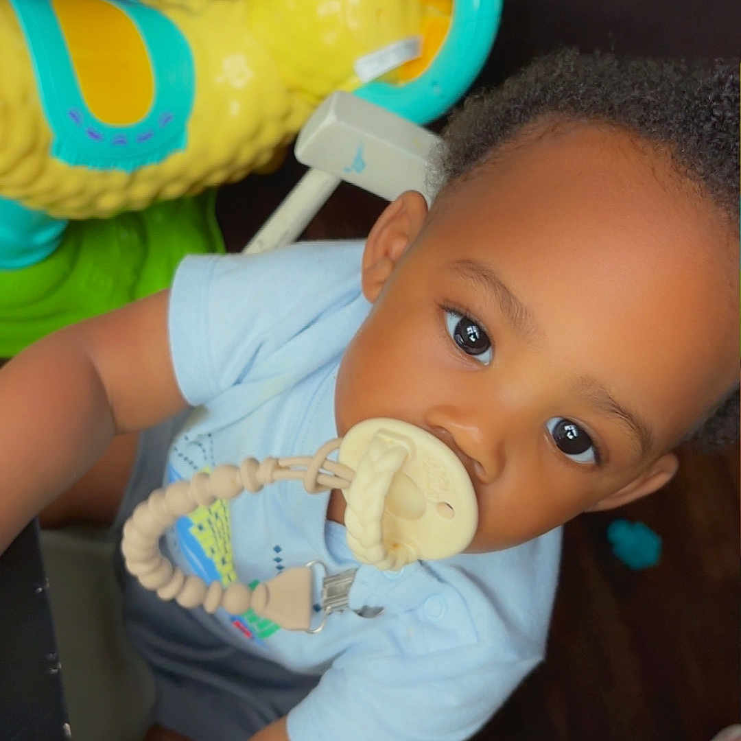 Braylon joined the competition — help win amazing prizes! toddler, child, pacifier, toy, indoor, curious, baby, clothing, face, person, playtime, bright_colors, hair, cute, infant, young_child, closeup, expression, seat, floor
