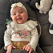 Mia a rejoint le concours — aidez-le/la à gagner de superbes lots ! baby, child, smiling, face, headband, clothing, car_seat, toy, pacifier, cute, indoor, person, infant, happy, seatbelt, fabric, soft_toy, mickey_mouse, closeup, sitting