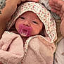 baby, infant, pacifier, pink_towel, floral_pattern, tattoo, hands, close_up, wrapped, cozy, sleepy, cute, newborn, soft_texture, blanket, person, face, skin, indoor, comfort