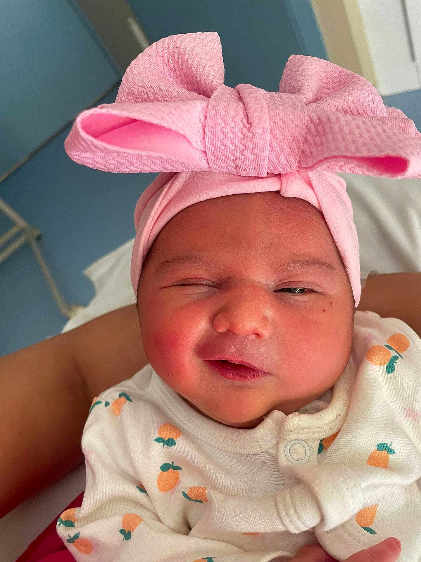 Carmen participe au concours pour gagner de l'argent avec cette photo : baby, newborn, infant, pink_headband, bow, onesie, fruit_pattern, sleepy, close_up, cute, child, portrait, person, soft_skin, adorable, clothing, wrapped, indoors, human, face