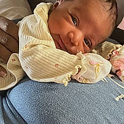 Shamari is registered to the contest to win money with this photo: baby, newborn, smile, face, person, clothing, hand, couch, leather, texture, skin, fabric, closeup, portrait, infant, comfort, resting, warm, indoor, cute