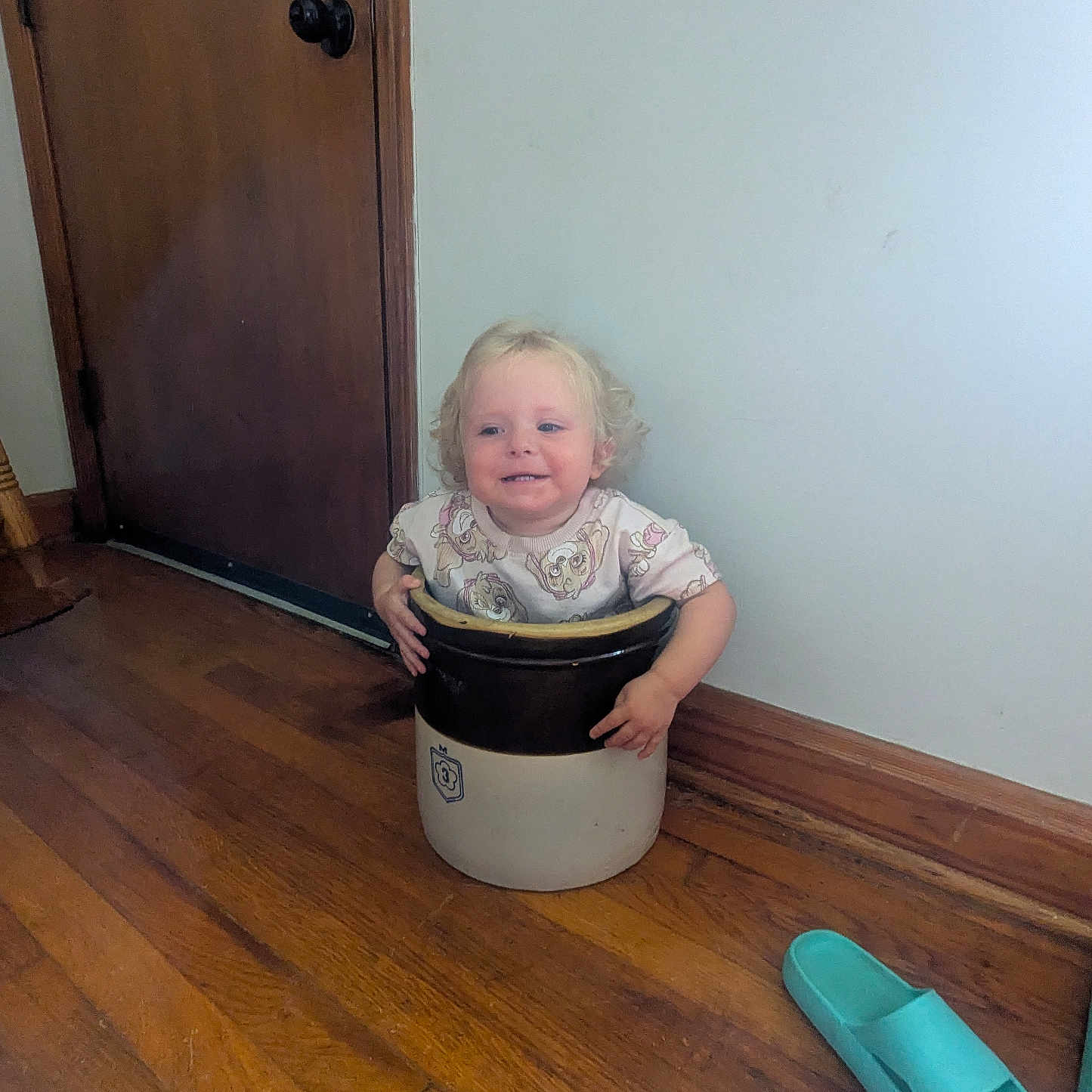 Phoenixx is registered to the contest to win money with this photo: blue_slipper, casual, ceramic_crock, child, curly_hair, cute, door, doorknob, flooring, hands, home, indoor, light, plain_wall, playful, sitting, slipper, smiling, toddler, wooden_floor