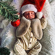 Jules participe au concours pour gagner de l'argent avec cette photo : baby, sleeping, santa_hat, christmas, holiday, ornament, pine_branch, blanket, cozy, infant, clothing, vest, pajamas, festive, holiday_decor, cute, soft, peaceful, portrait, indoor