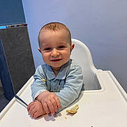 Elio participe au concours pour gagner de l'argent avec cette photo : baby, bread, chair, child, crumbs, cute, face, feeding, hands, happy, highchair, indoor, infant, mealtime, portrait, shirt, smile, spoon, table, wall