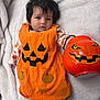 Siya joined the competition — help win amazing prizes! baby, blanket, bucket, child, clothing, costume, cute, face, festive, halloween, holiday, indoor, infant, lying_down, orange, person, plastic, pumpkin, smile, toy