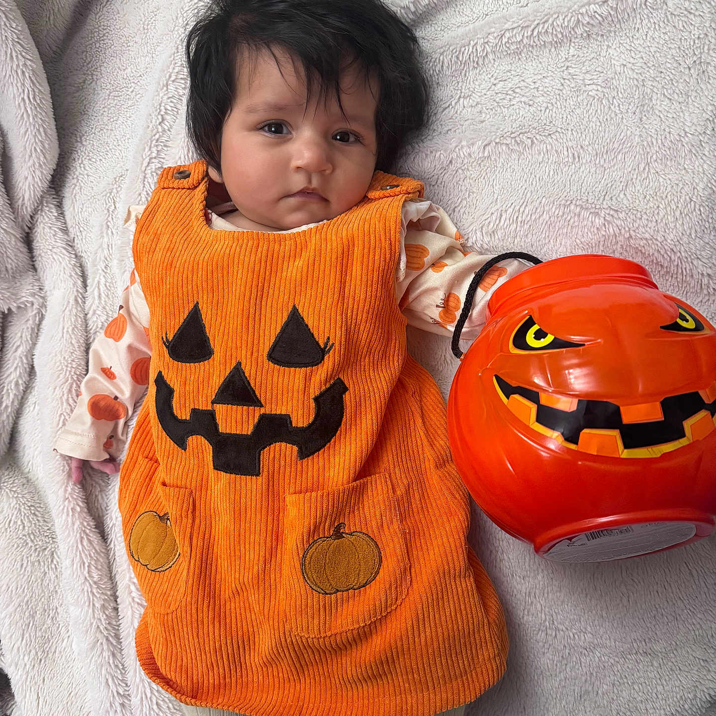Siya joined the competition — help win amazing prizes! baby, blanket, bucket, child, clothing, costume, cute, face, festive, halloween, holiday, indoor, infant, lying_down, orange, person, plastic, pumpkin, smile, toy