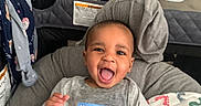 Roderick is registered to the contest to win money with this photo: baby, blanket, child, clothing, cushion, face, furniture, happy, head, home, household, indoor, infant, laundry_basket, person, playful, seated, shirt, smiling, sticker