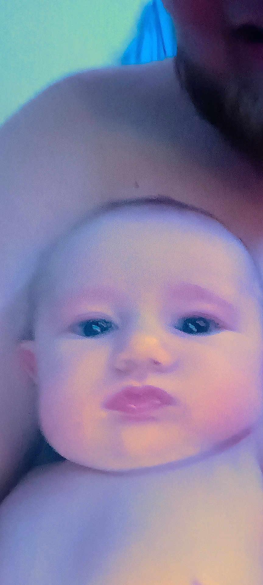 Noel joined the competition — help win amazing prizes! baby, face, closeup, skin, shoulder, adult, child, portrait, expression, pout, blue_tint, soft_focus, indoor, person, head, cute, young, human, infant, holding