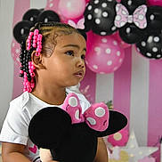 Tyaisia is registered to the contest to win money with this photo: balloons, birthday_party, black, celebration, child, curly_hair, cute, hair_beads, holding, indoor, minnie_mouse, party_decorations, pink, plush_toy, polka_dots, portrait, side_profile, toddler, white_shirt, young_child