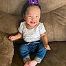 baby, child, smiling, sitting, portrait, indoors, couch, furniture, purple_bow, white_shirt, blue_jeans, pink_socks, happy, infant, face, arms, hands, home, fashion, photography