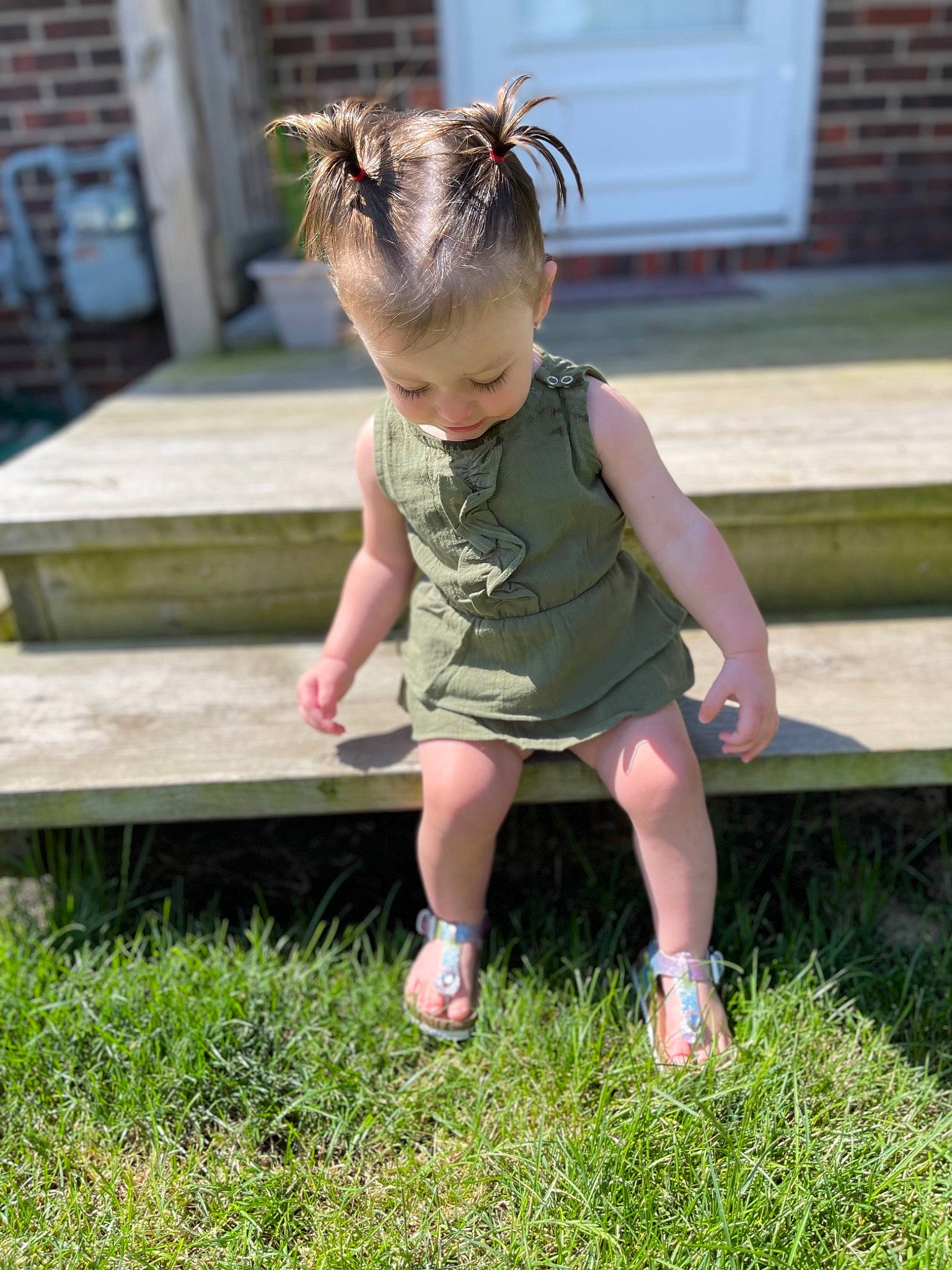 Kynsleigh is registered to the contest to win money with this photo: baby, baby_toddler_clothing, blond, child, dress, eyewear, foot, fun, grass, grass_family, happy, human_leg, lawn, leisure, pattern, people_in_nature, person, plant, sandal, sitting
