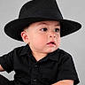 baby, child, portrait, fedora, hat, black_clothing, shirt, studio, gray_background, sitting, face, eyes, serious_expression, open_mouth, looking_away, fashion, closeup, indoor, photography, adorable